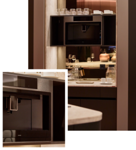 INKO Cocinas: cocina moderna de diseño premium con electrodoméstico empotrado, encimera clara y estantes iluminados con cristalería.