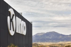 INKO Cocinas logotipo 3D blanco en fachada negra de edificio, paisaje montañoso al fondo, diseño premium