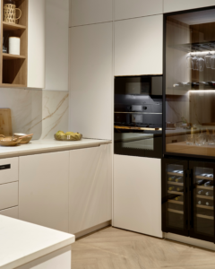 Cocina moderna minimalista en lacado blanco mate con encimera de piedra, madera cálida, iluminación integrada y vinoteca – INKO Cocinas