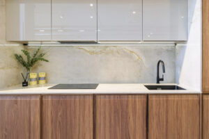 Cocina moderna con acabados en madera natural y encimera de mármol, combinando elegancia y funcionalidad – INKO Cocinas, fabricantes en Málaga.