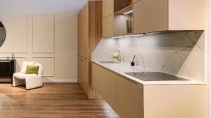 Cocina moderna con acabados en lacado beige y encimera de piedra, combinando calidez y elegancia – INKO Cocinas, fabricantes en Málaga.