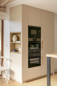 Cocina de diseño minimalista en lacado crema con estantes en madera, electrodomésticos integrados y líneas rectas – INKO Cocinas