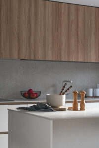 INKO | Fabricantes de Cocinas en Málaga y Diseño a Medida | INKO Cocinas: cocina moderna con frentes de madera, isla clara, utensilios en cuenco y molinillos; diseño premium.